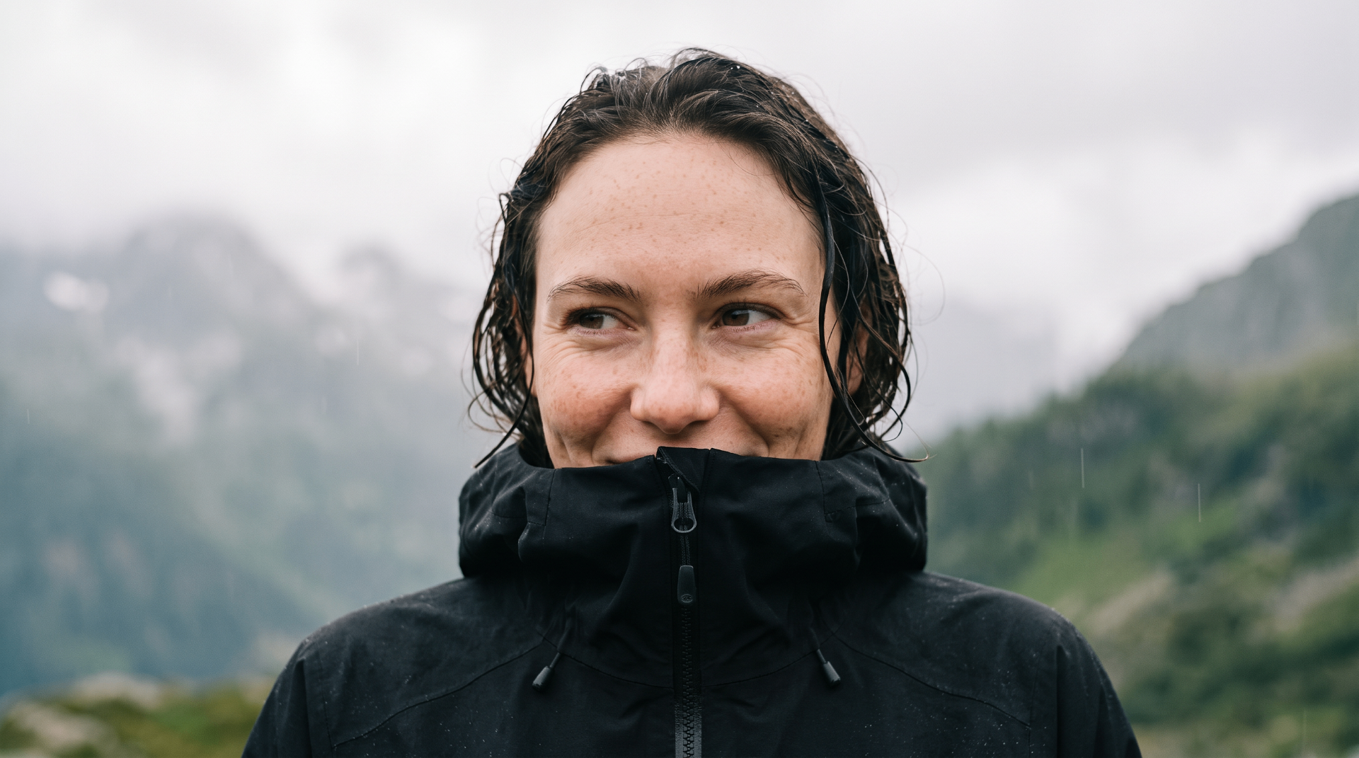 AI-generated character wearing a black rain jacket against a misty mountain landscape